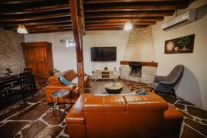 利馬索爾的住宿－The Stonehouse Suites，客厅配有皮革家具和壁炉