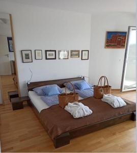 Bett mit Körben darüber in einem Zimmer in der Unterkunft Ferienwohnung INA am Bodensee mit Schwimmbad und Sauna in Uhldingen-Mühlhofen