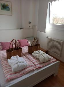 ein Bett mit zwei Körben darüber in der Unterkunft Ferienwohnung INA am Bodensee mit Schwimmbad und Sauna in Uhldingen-Mühlhofen
