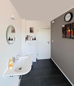 a bathroom with a white sink and a black tile floor at Cozy Inn Schladern in Windeck