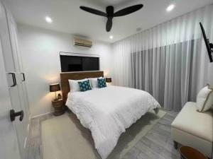 a bedroom with a bed and a ceiling fan at Indigo Apartment with Pool 200m to Beach in Palm Cove