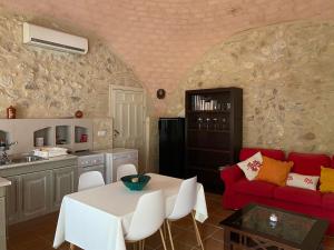 a living room with a table and a red couch at Viña Zarzarrosa Osuna in Osuna