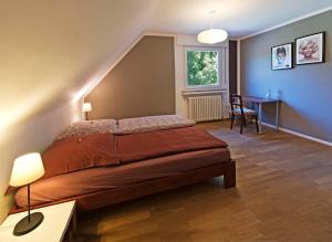 a bedroom with a bed and a table and a chair at Cozy Inn Schladern in Windeck