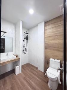 La salle de bains est pourvue de toilettes et d'un lavabo. dans l'établissement โรงแรม ชม เชียงราย, à Ban Hua Khwai (1)