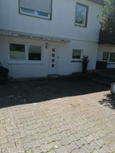 a white house with a brick driveway in front of it at Gemütliches Appartment in Homberg Stadtmitte in Homberg