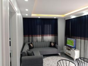 PRETTY HOUSE في باموكالي: غرفة معيشة بها أريكة وتلفزيون