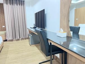 une salle de conférence avec une table et des chaises en verre dans l'établissement โรงแรม ชม เชียงราย, à Ban Hua Khwai (1)