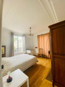 ein Schlafzimmer mit einem Bett und einem großen Fenster in der Unterkunft Appartement 2 chambres 60m2 in Neuilly-sur-Seine
