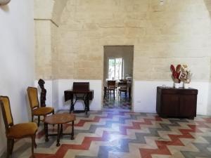 a room with chairs and tables and a wall at Dimora Margherita in Salento in Struda