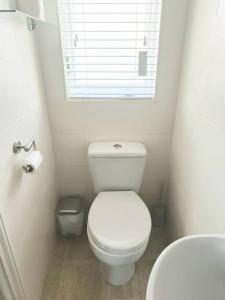 a small bathroom with a white toilet and a window at Foxhollow House in Blarney