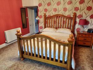 a bedroom with a wooden crib and a bed with a table at Thorndene B&B in Hope