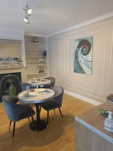 a living room with two tables and chairs and a painting at Foxhollow House in Blarney