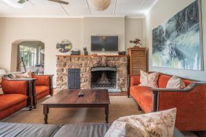a living room with a couch and a fireplace at Tygerfontein Safari Villa in Amakhala Game Reserve