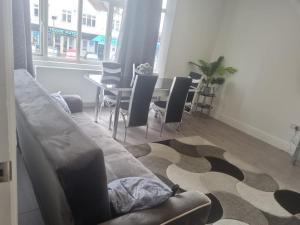 a living room with a couch and a table with chairs at Attractive 2 bed apartments free Wi-Fi and parking in Croydon