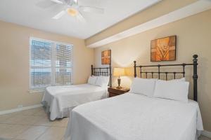 a bedroom with two beds and a ceiling fan at Beach Colony East 9C in Perdido Key