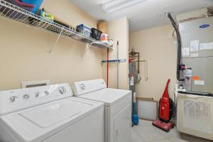 a laundry room with a washing machine and a refrigerator at Beach Colony East 9C in Perdido Key