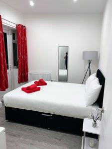 a bedroom with a large bed with red towels on it at Attractive 2 bed apartments free Wi-Fi and parking in Croydon