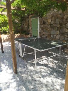 a ping pong table in front of a stone wall at B&B Casa Corbezzolo in Procchio