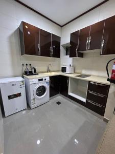 a kitchen with a washing machine and a washer at الاتحاد الذهبية للشقق المخدومة 3 in Al Hofuf