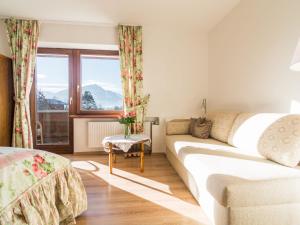 ein Wohnzimmer mit einem Sofa und einem Fenster in der Unterkunft Charming Apartment in Kirchdorf in Tirol near City Centre in Kirchdorf in Tirol