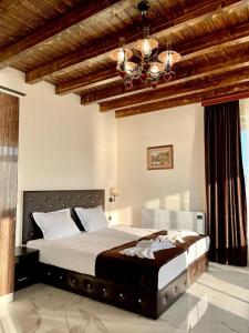 a bedroom with a large bed and a chandelier at Villa ART in Dospat