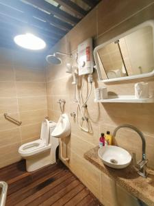 W łazience znajduje się toaleta, umywalka i lustro. w obiekcie Collection O 90861 Bentong Nature Orchard Homestay w mieście Kampong Sungai Chendarawi