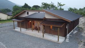 a house with a metal roof on top of it at Goto Backpackers Pole in Shinkamigoto