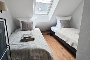 Habitación pequeña con 2 camas y ventana en Friends&Family Veldenz M, en Veldenz