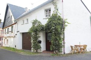 a white house with a door and a table at Friends&Family Veldenz M in Veldenz
