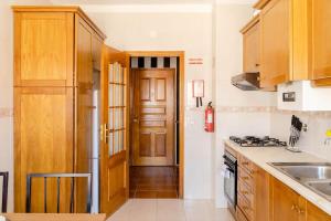 a kitchen with wooden cabinets and a stove top oven at Miguel Torga Gold Deluxe in Coimbra +20 photos