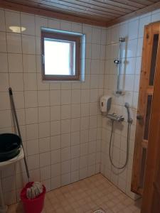 ein Bad mit einer Dusche und einem Fenster in der Unterkunft Himos, KOIVULA 25, center area in Jämsä