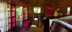 a room with a couch and chairs in a house at Sang Tong Huts in Mae Hong Son