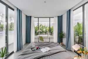 a bedroom with a large bed and large windows at M Village Điện Biên Phủ Q3 in Ho Chi Minh City