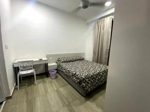 1 dormitorio con cama, escritorio y silla en The Stay Guest House @ Kenwingston Residence en Cyberjaya