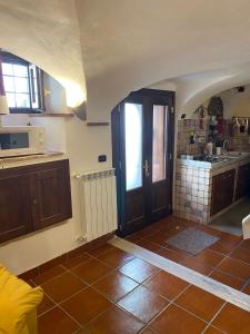 una cucina con porta e pavimento piastrellato di la casa di Sophie a Pettorano sul Gizio