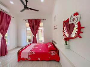 ein rotes Bett in einem weißen Zimmer mit roten Vorhängen in der Unterkunft HELLOKITTY HOUSE - Unit 1 in Kuala Terengganu