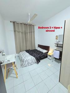 a bedroom with a bed and a table in a room at Dieyra Homestay in Kuala Terengganu