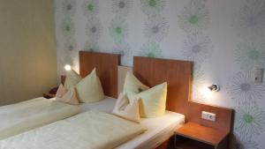 a bedroom with two beds with white pillows at Hotel Krone Rüdesheim in Rüdesheim am Rhein