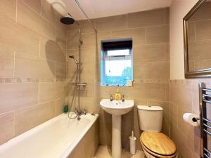 La salle de bains est pourvue d'un lavabo, de toilettes et d'une baignoire. dans l'établissement Daisy’s Place in London, à Londres