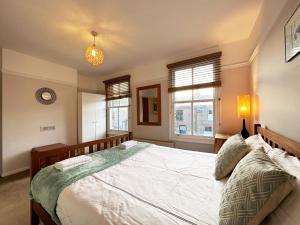 a bedroom with a large bed and two windows at Daisy’s Place in London in London