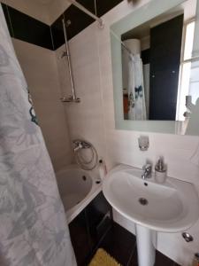 a bathroom with a sink and a tub and a mirror at Ušće apartman in Novi Beograd
