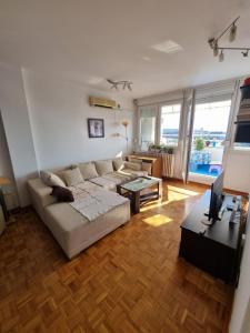 Novi Beograd的住宿－Ušće apartman，客厅配有沙发和桌子