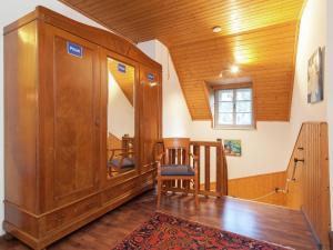 ヘルマゴルにあるLarge modern holiday home in Hermagor Pressegger See Carinthia with poolの木製のキャビネット、テーブルと椅子が備わる客室です。