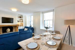 - un salon avec une table et un canapé bleu dans l'établissement Cwm Seren - Luxury Apartment, à Crickhowell