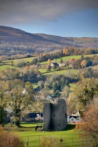 un castillo en medio de un campo verde en Cwm Seren - Luxury Apartment, en Crickhowell