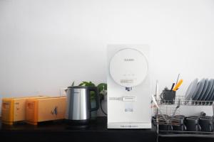 a kitchen counter with a coffee maker and a mirror at Sleep Here Hostel, Melaka in Melaka