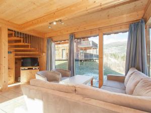 a living room with a couch and a table at Cosy Chalet in Stadl an der Mur with Valley Views in Stadl an der Mur