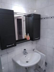ein weißes Badezimmer mit einem Waschbecken und einem Spiegel in der Unterkunft Seeperle 3, Wunderschöne Maisonett Ferienwohnung unter Reet! in Sankt Peter-Ording
