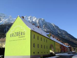 a yellow building with a sign in front of a mountain at Hilltop Apartment in Eisenerz with Garden in Eisenerz