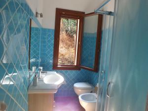 モンテ・ナイにあるVilla Isabelの青いタイル張りのバスルーム(トイレ、シンク付)
